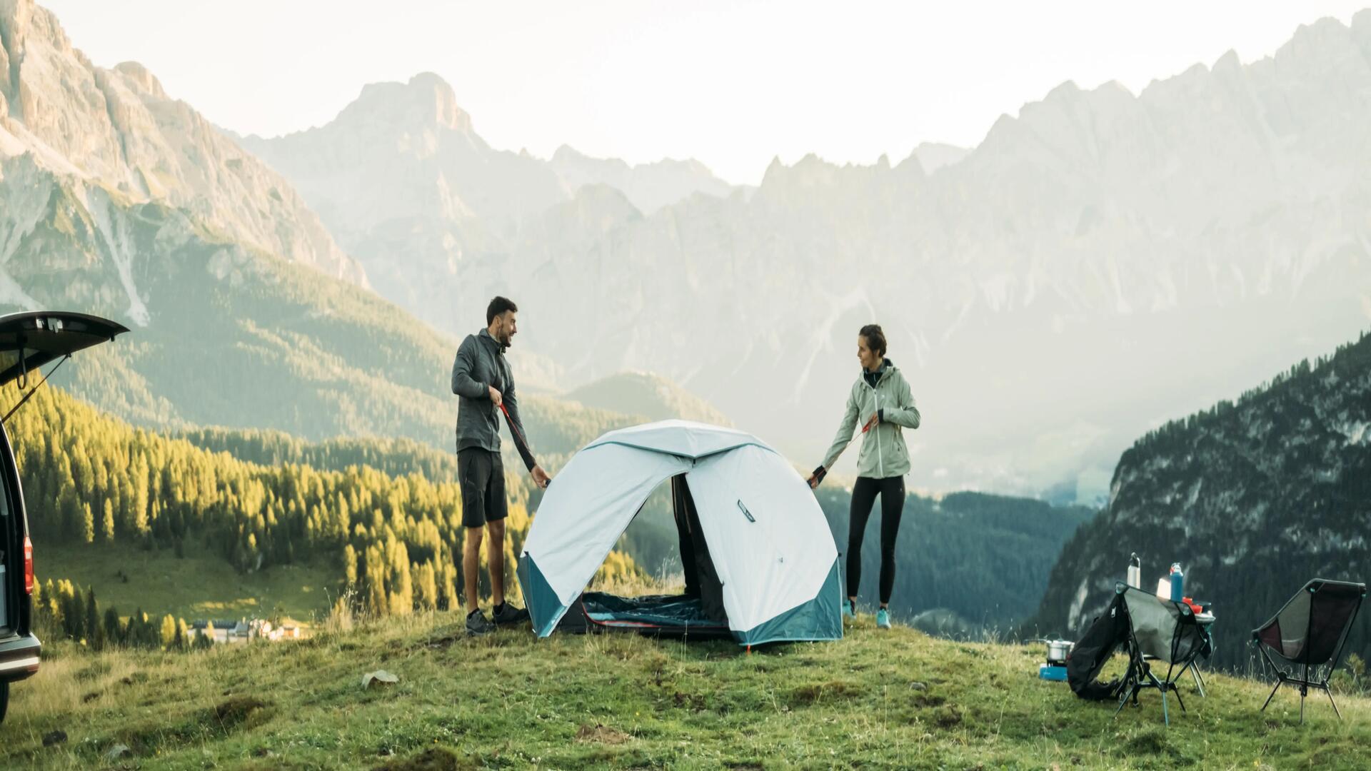 Man and woman putting up a tent