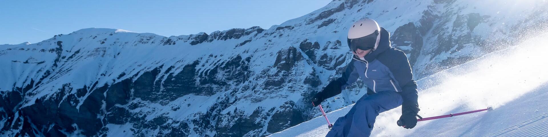 chłopiec w stroju narciarskim zjeżdżający na nartach ze stoku