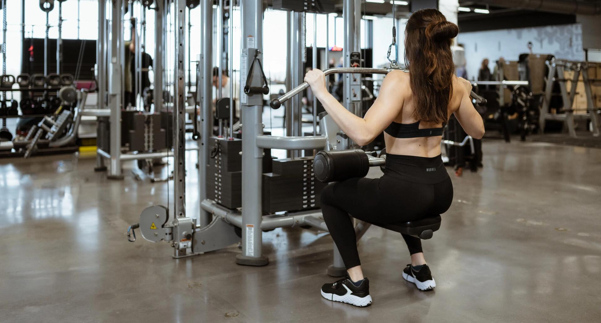 mujer haciendo espalda en gimnasio