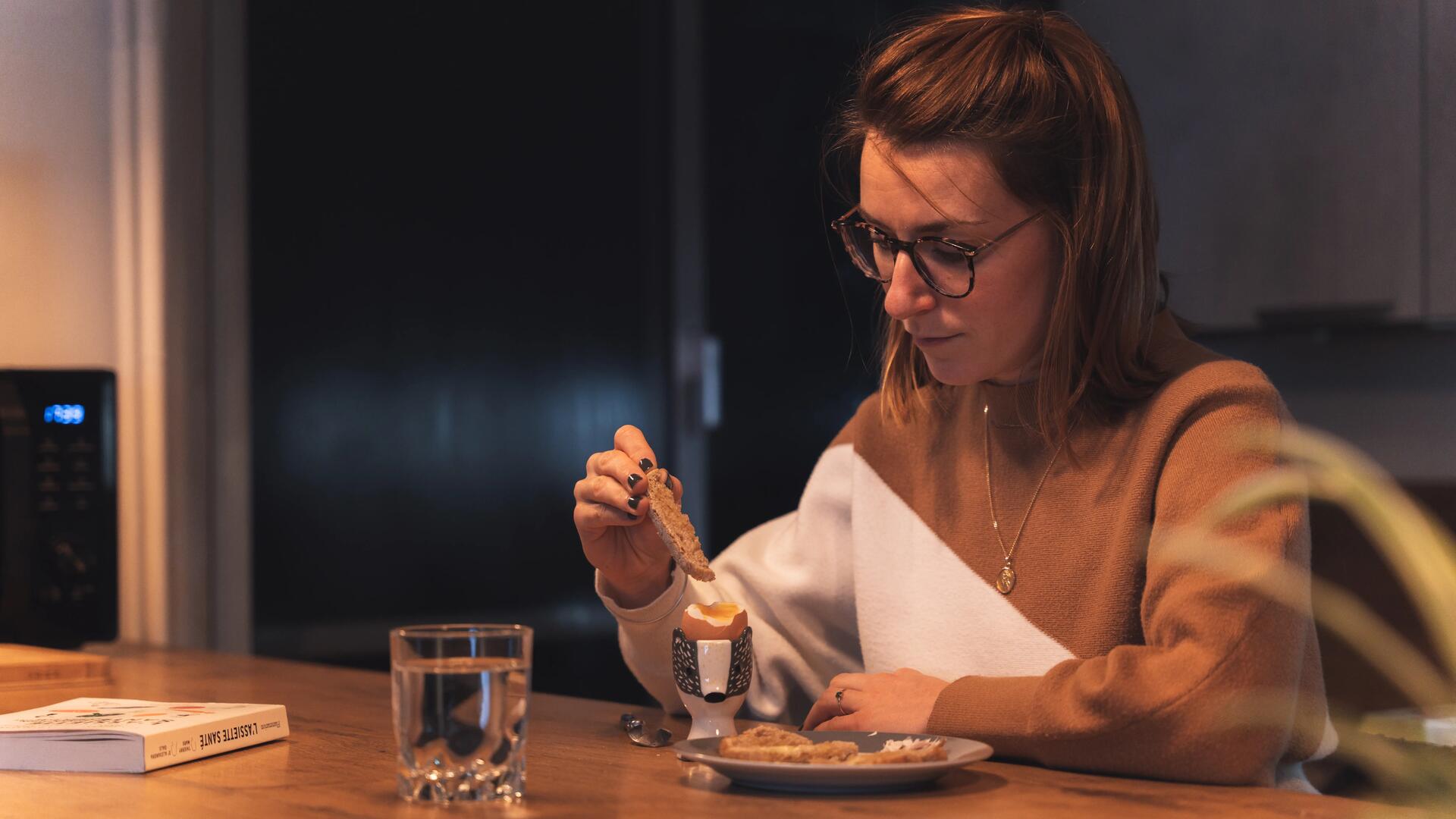 une femme qui mange son oeuf à la coque