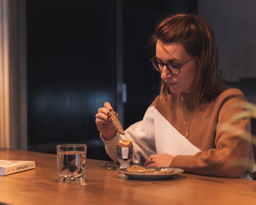 une femme qui mange son oeuf à la coque