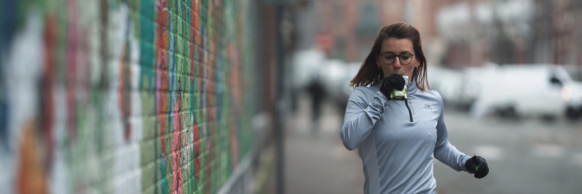 Jeune femme consommant de la nutrition sportive en courant