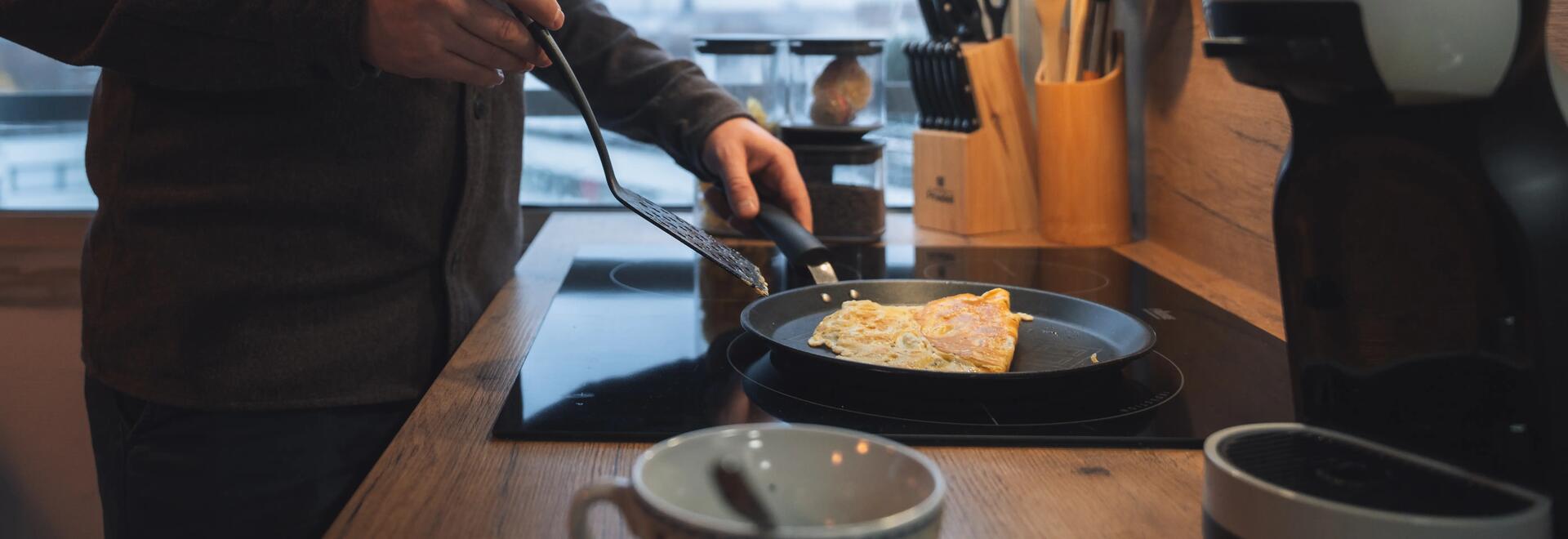 Jeune homme se préparant une omelette