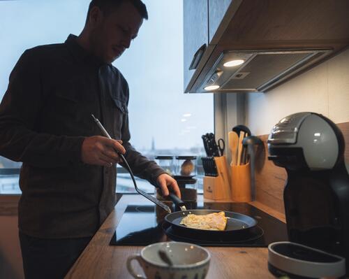 Jeune homme se préparant une omelette