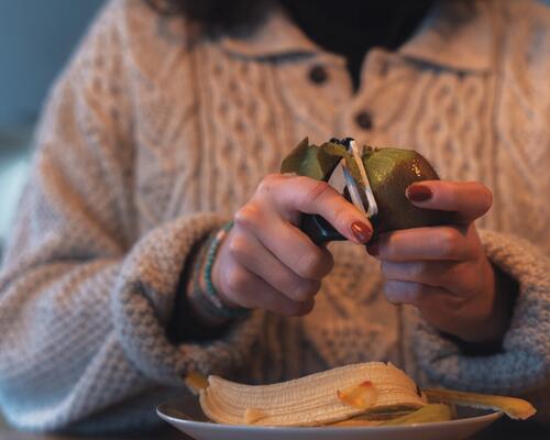 Jeune fille épluchant un kiwi