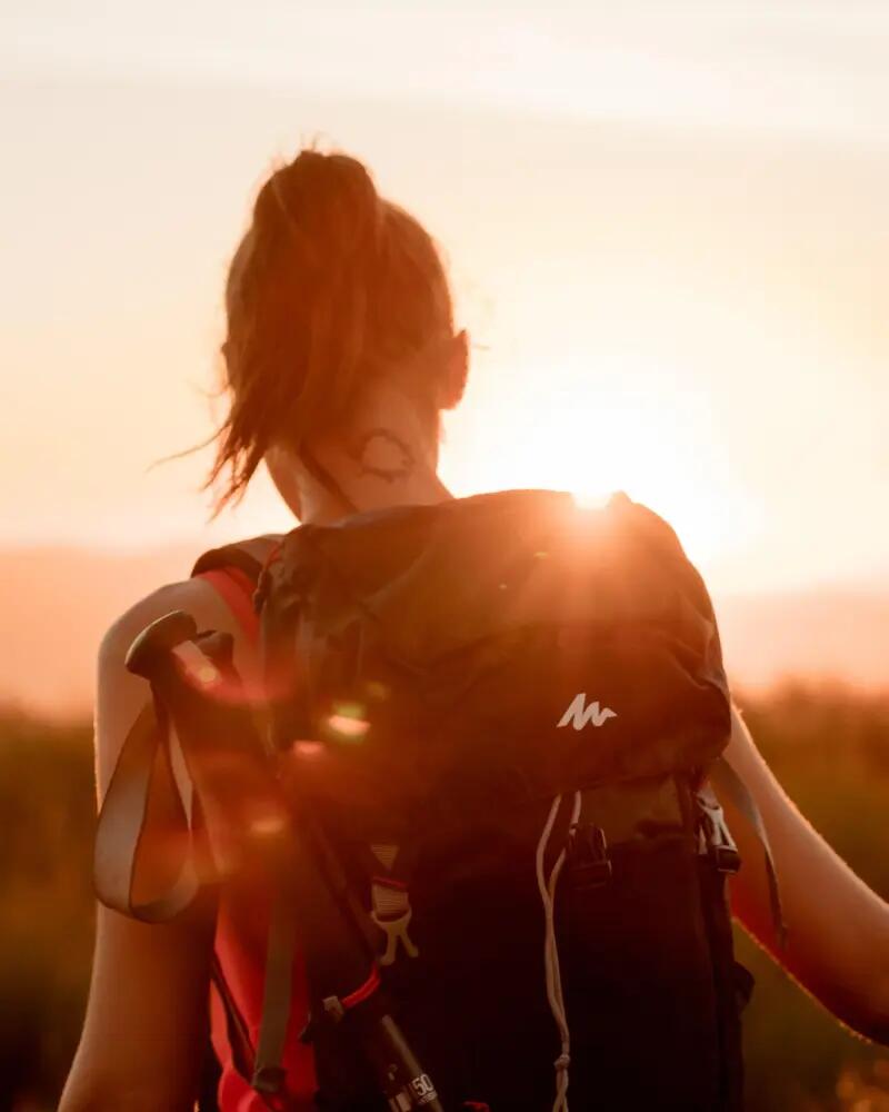 Žena otočená zády s turistickým batohem na zády.