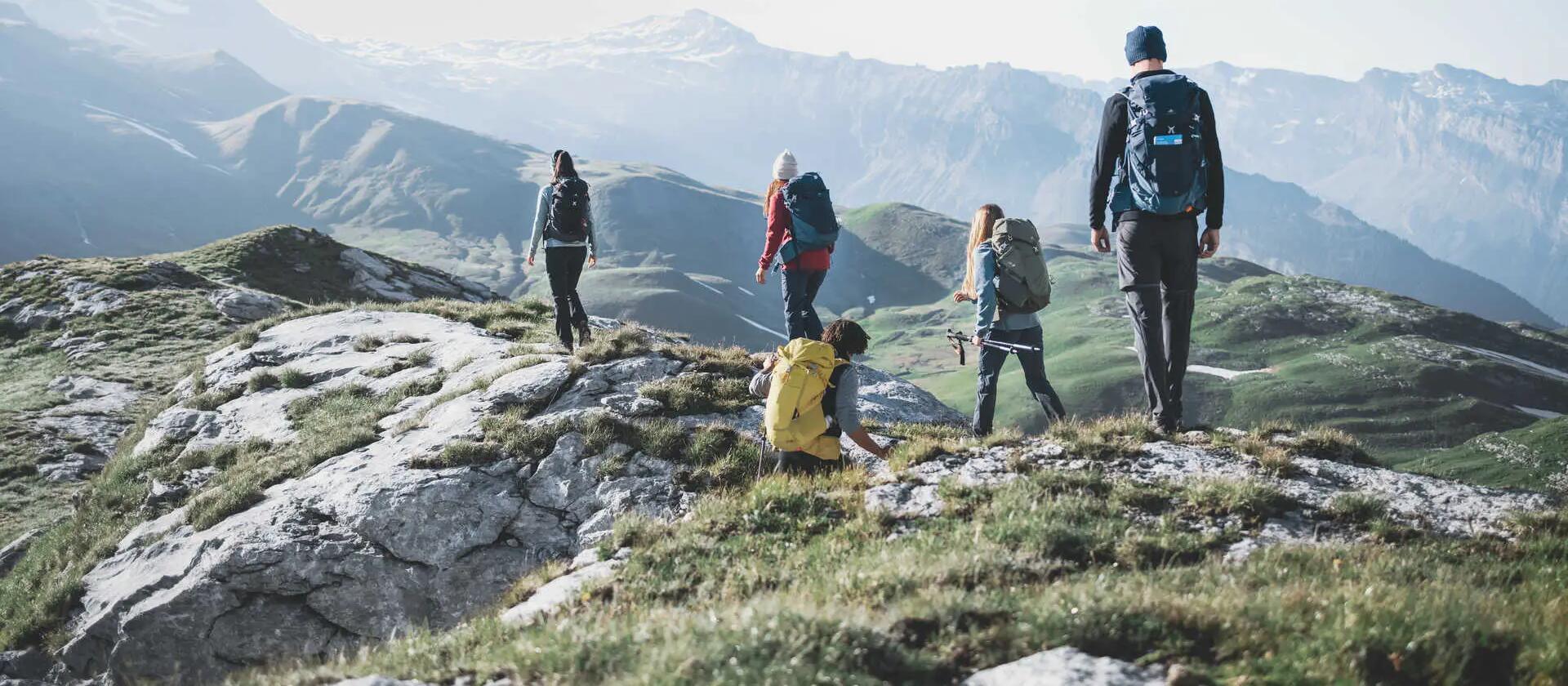 ludzie w odzieży trekkingowej wędrujący po górach