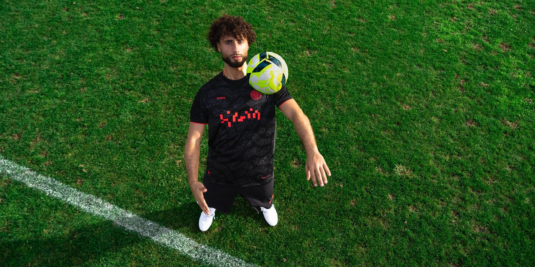 Man playing with football on pitch