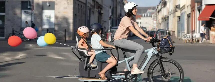 Mother cycling with kids at the back