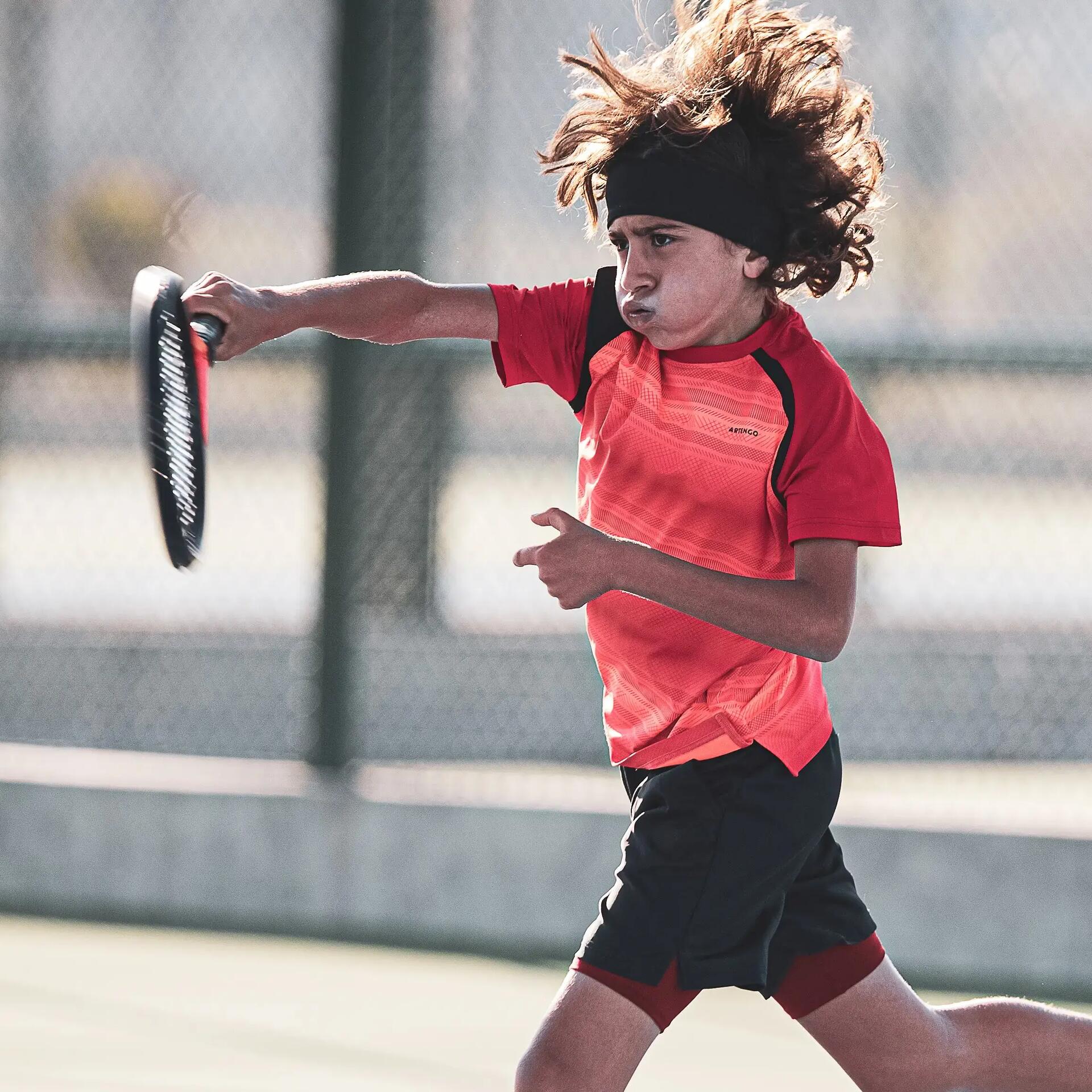 petit garçon avec sa raquette de tennis sur le terrain