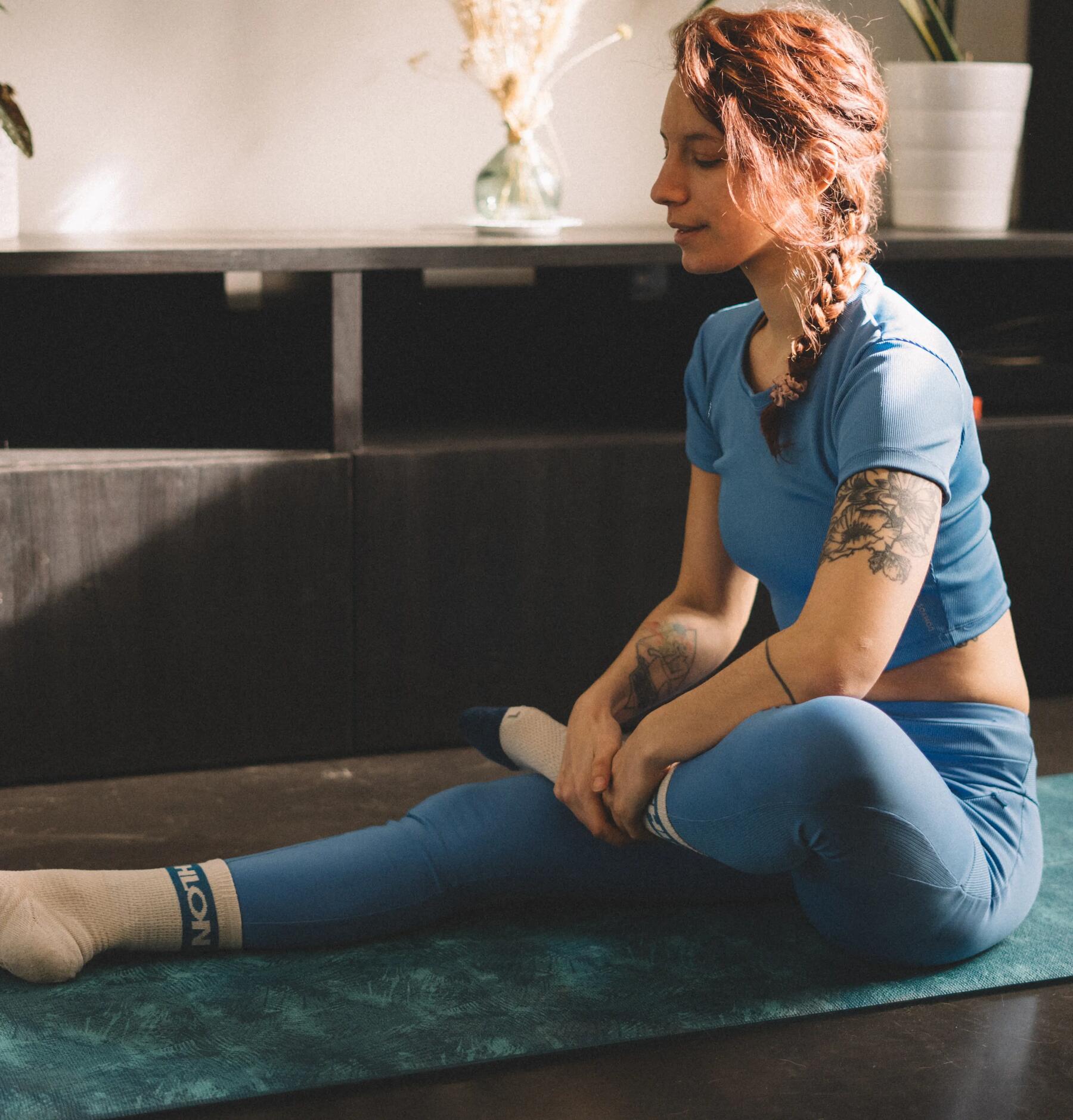 Woman stretching legs on mat