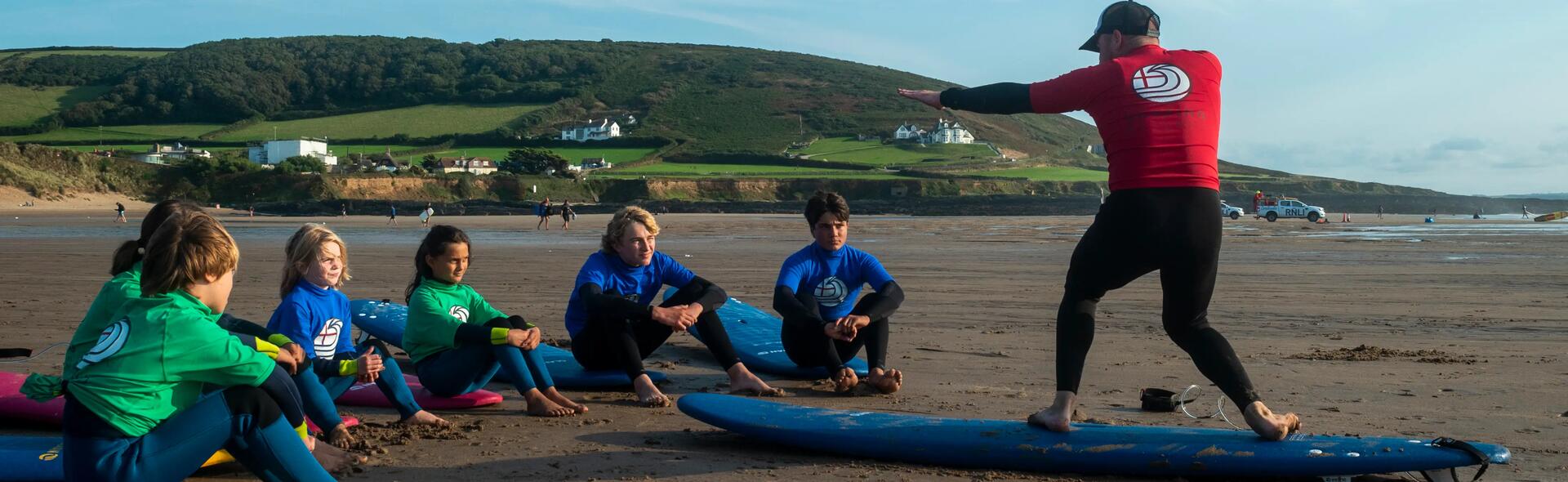 Man teaching surfing to students.